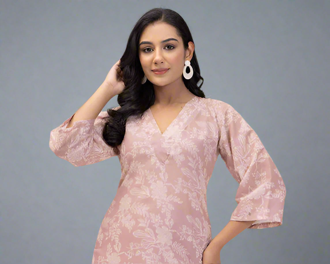 Woman wearing a pink floral dress against a gray background